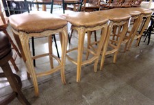 VERY CLASSY BAR STOOLS.   Tan leather seats upon queen-anne shaped pedestals with ornate engraving.  Set of 5 for price.  
$250.00